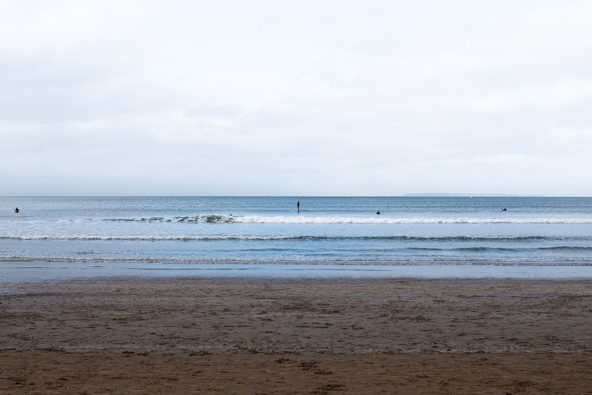 The Beach in Winter - Isolated Surfers at sea shown as black dots