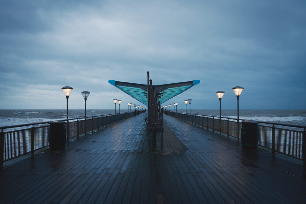 almost empty pier at the beach in winter blue hour